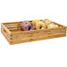 A natural bamboo shallow rectangular basket filled with bagels and donuts.