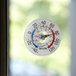 A Taylor stick-on outdoor window thermometer on a window.
