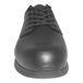 A close up of a black Genuine Grip men's leather shoe with laces and rubber soles.