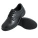 A pair of black Genuine Grip leather shoes with laces and black rubber soles.