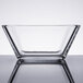 A clear square Libbey glass bowl on a reflective surface.