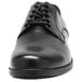 A black Genuine Grip men's Oxford dress shoe with laces.