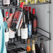 A person holding a bottle of wine in a Beverage-Air wine refrigerator rack.