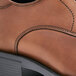 A close-up of a brown Shoes For Crews Senator dress shoe with a black sole.