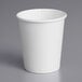 A white paper cup on a gray surface.
