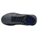 A black Shoes For Crews women's athletic shoe with a blue sole.