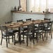 A Lancaster Table & Seating rectangular butcher block table with plates and chairs on it.