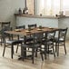 A Lancaster Table & Seating rectangular wood butcher block table with chairs around it.