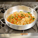 A Vollrath Wear-Ever saute pan filled with noodles and vegetables on a stove.