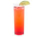 A Libbey straight sided glass filled with an orange drink and a lime wedge.