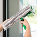 A person holding a green and black Unger Ninja window cleaning sleeve