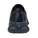 A black Shoes For Crews women's athletic shoe with a blue square logo on the back.