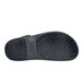 The bottom of a black Shoes For Crews slide sandal with a white background.