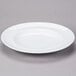An Arcoroc white porcelain dinner plate with a rim.