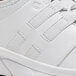 A close up of a white Shoes For Crews Karina women's athletic shoe with black laces.