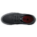 A black Shoes For Crews Cabbie II men's casual shoe with a red sole.