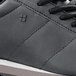 A close up of a black Shoes for Crews Avery athletic shoe with a white sole.