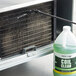 A bottle of Noble Chemical Tech Line Evaporator Coil Cleaner next to a window air conditioner.