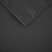 A close up of a black rectangular table cloth with a hemmed edge.