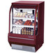 A red Turbo Air refrigerated deli case with food on shelves.