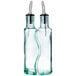 Two Tablecraft clear glass olive oil bottles with metal tips.