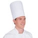 A man wearing a white Royal Paper pleated chef hat.