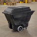 A Rubbermaid black plastic container on wheels.