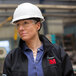 A woman wearing a 3M hard hat and safety glasses.