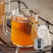 A glass mug of Numi Organic Chocolate Rooibos tea with a tea bag in it.
