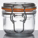An Anchor Hocking mini glass jar with an orange metal lid.