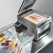 A Hamilton Beach sous vide machine with vegetables in it on a counter.