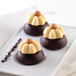 A white plate with three chocolate desserts made using a Silikomart mini Charlotte silicone baking mold.