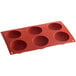 A red Silikomart silicone baking tray with six half sphere cavities.