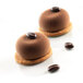 A round brown chocolate dessert in a Silikomart silicone baking mold with a coffee bean on top.
