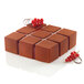 A square shaped chocolate cake with red berries in a Silikomart CUBIK silicone baking mold.