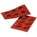 A red silicone baking tray with six half spheres.