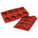 A red Silikomart silicone heart-shaped baking mold.
