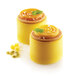 Yellow desserts with swirls on top in Silikomart Tourbillon silicone baking molds on a table with mint leaves.