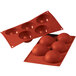 A red silicone baking mold with half-sphere cavities.
