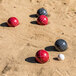 A group of Triumph resin bocce balls on the sand.