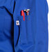 A royal blue Uncommon Chef long sleeve chef coat with a red pen and pen holder in the pocket.