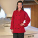 A woman wearing a red Uncommon Chef long sleeve chef coat.