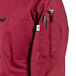 A burgundy Uncommon Chef long sleeve chef coat with a pocket and pen holder.