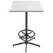 A white Holland Bar Stool bar height table with a wood laminate top and metal base with foot rest.