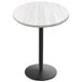 A white round table with a black round base.