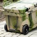 A green and tan CaterGator cooler with black wheels.