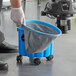 A person using a Lavex commercial wet/dry vacuum to clean up a blue bucket.