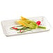 A white rectangular Solia sugarcane plate with a vegetable on it.