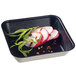 A Solia black square tray with sliced radish and herbs.