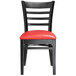 A Lancaster Table & Seating black wood ladder back chair with red vinyl seat.